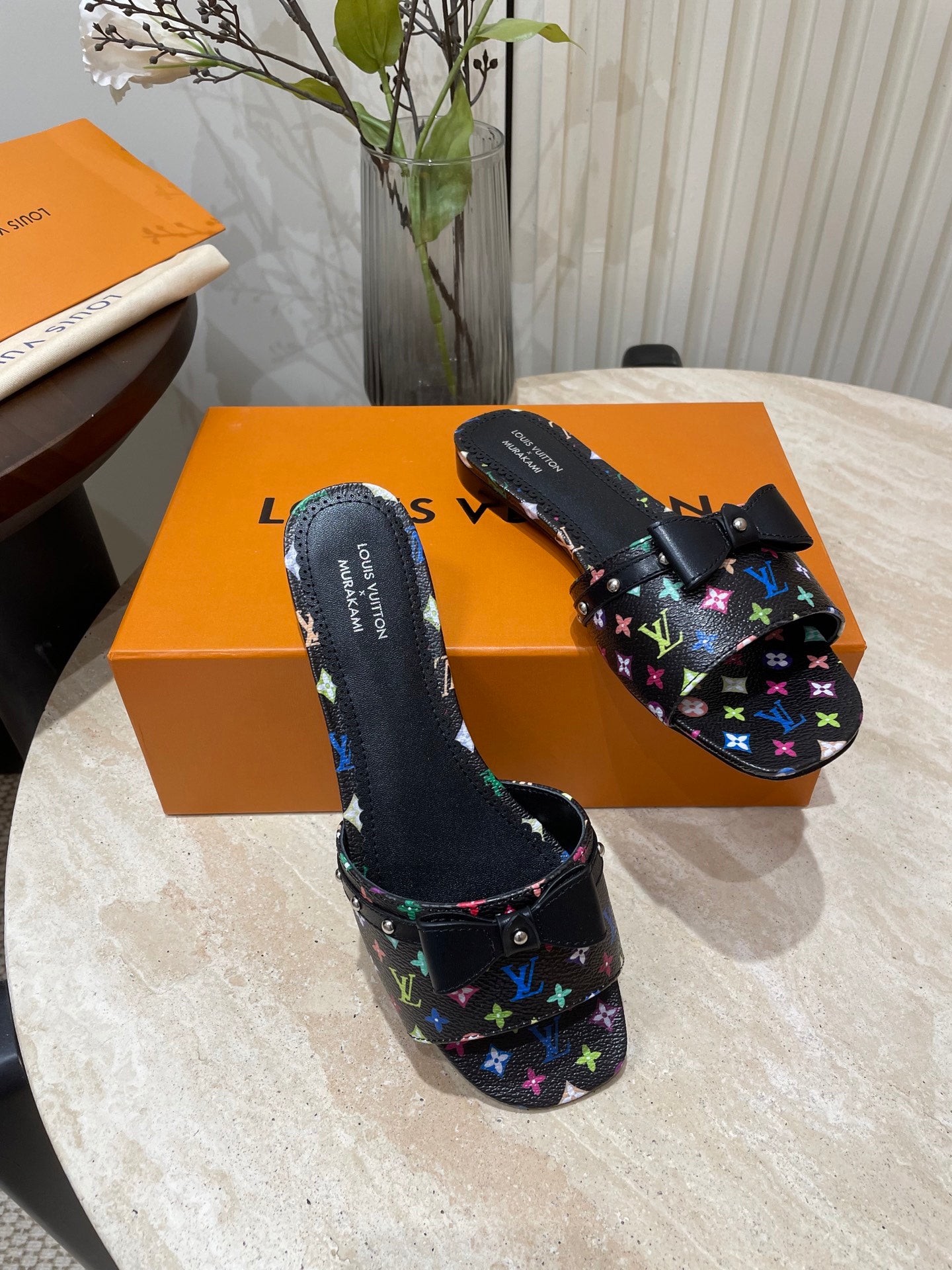 BOW FLAT MULES IN BLACK MONOGRAM LAMBSKIN