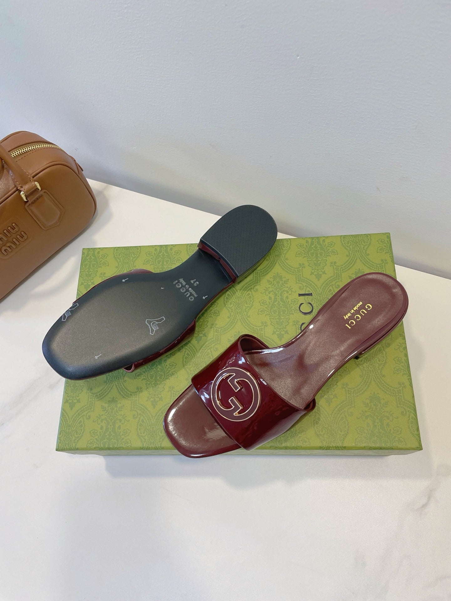 SLIDE SANDALS IN WINE RED GLOSSY SHEEPSKIN ENAMELLED ROUND INTERLOCKING G