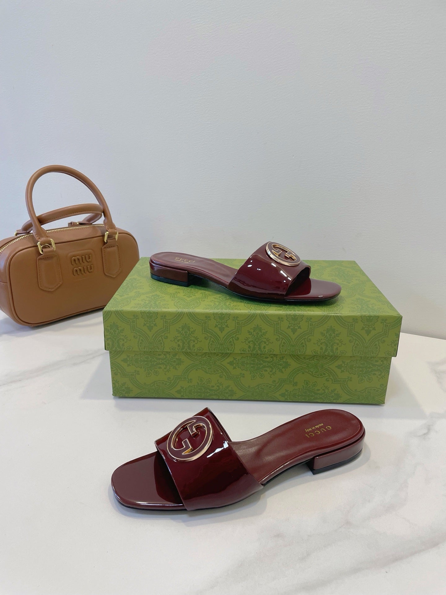 SLIDE SANDALS IN WINE RED GLOSSY SHEEPSKIN ENAMELLED ROUND INTERLOCKING G