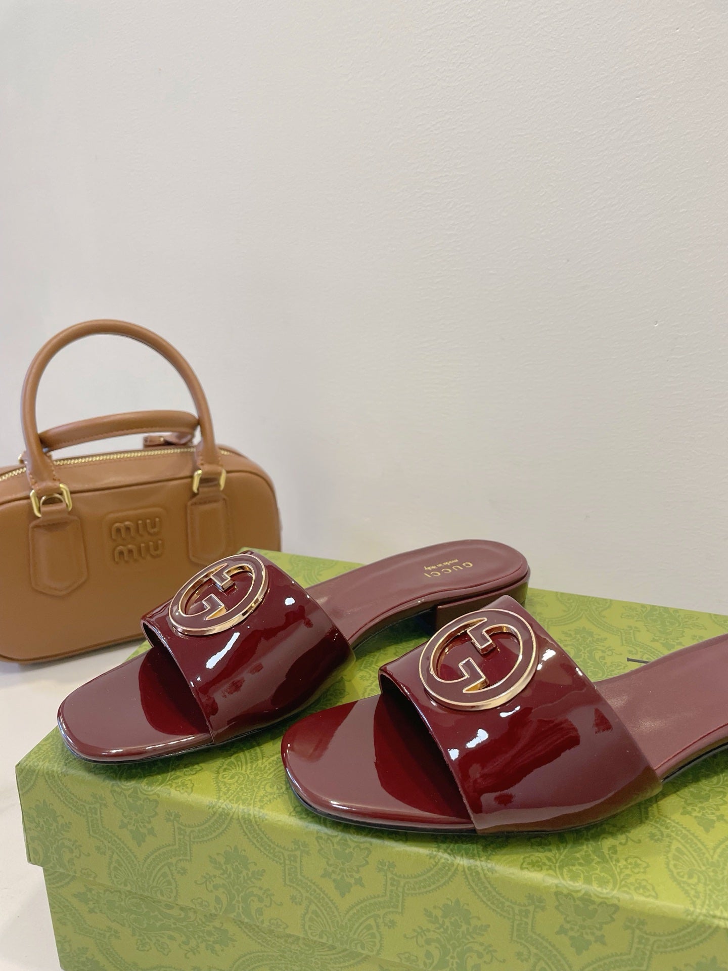 SLIDE SANDALS IN WINE RED GLOSSY SHEEPSKIN ENAMELLED ROUND INTERLOCKING G