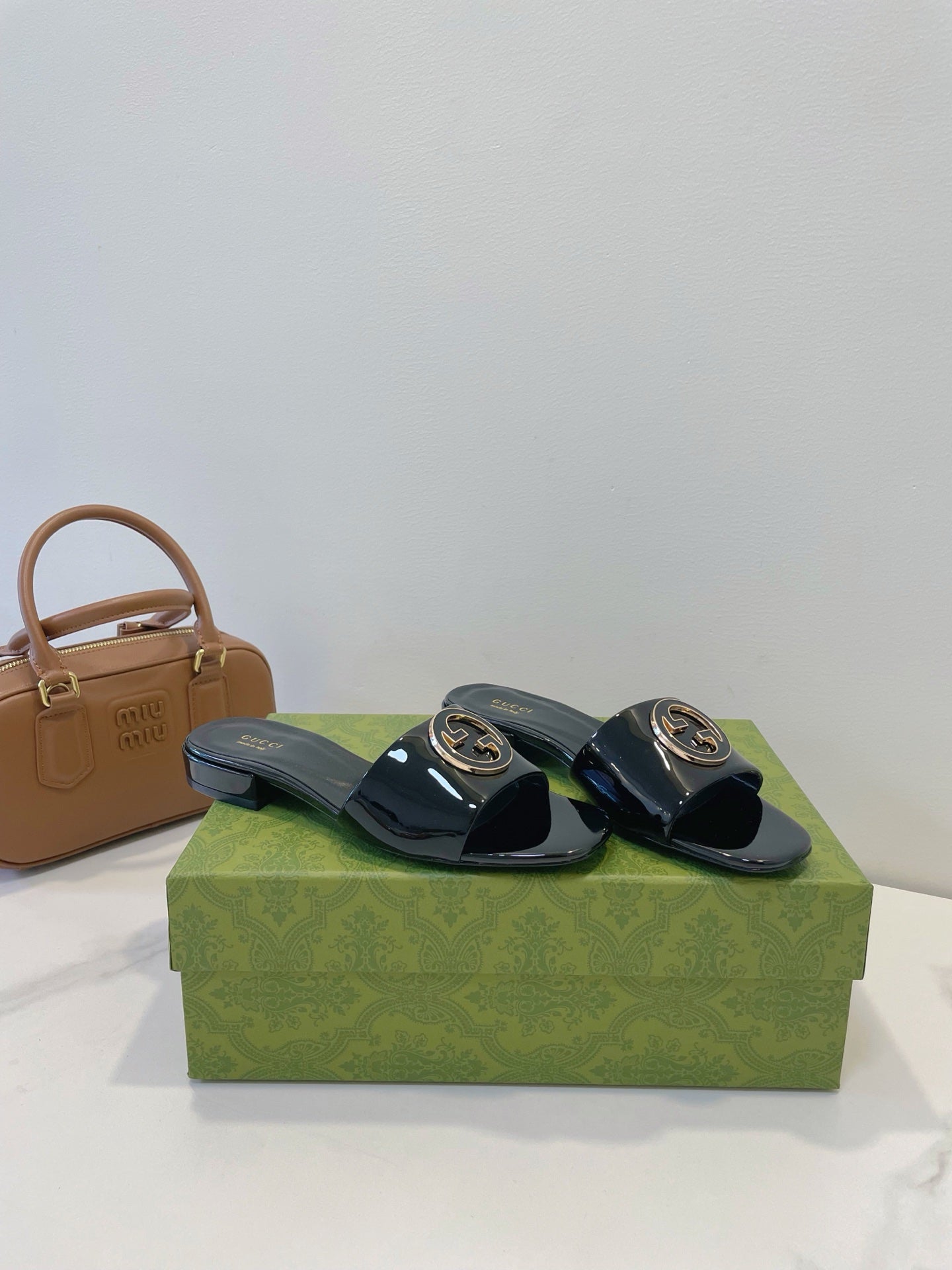 SLIDE SANDALS IN BLACK GLOSSY SHEEPSKIN ENAMELLED ROUND INTERLOCKING G